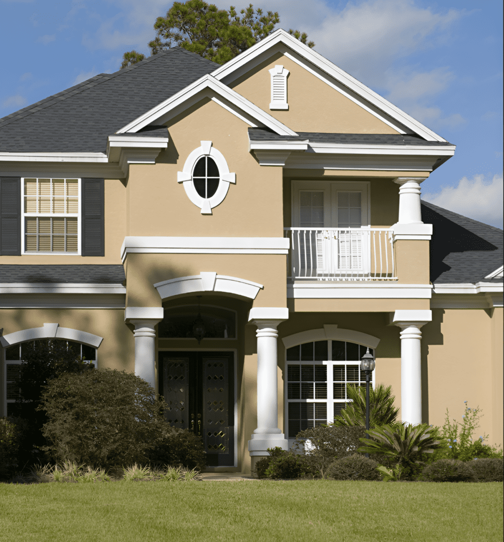 Two-story beige house with white trim and columns at the entrance.