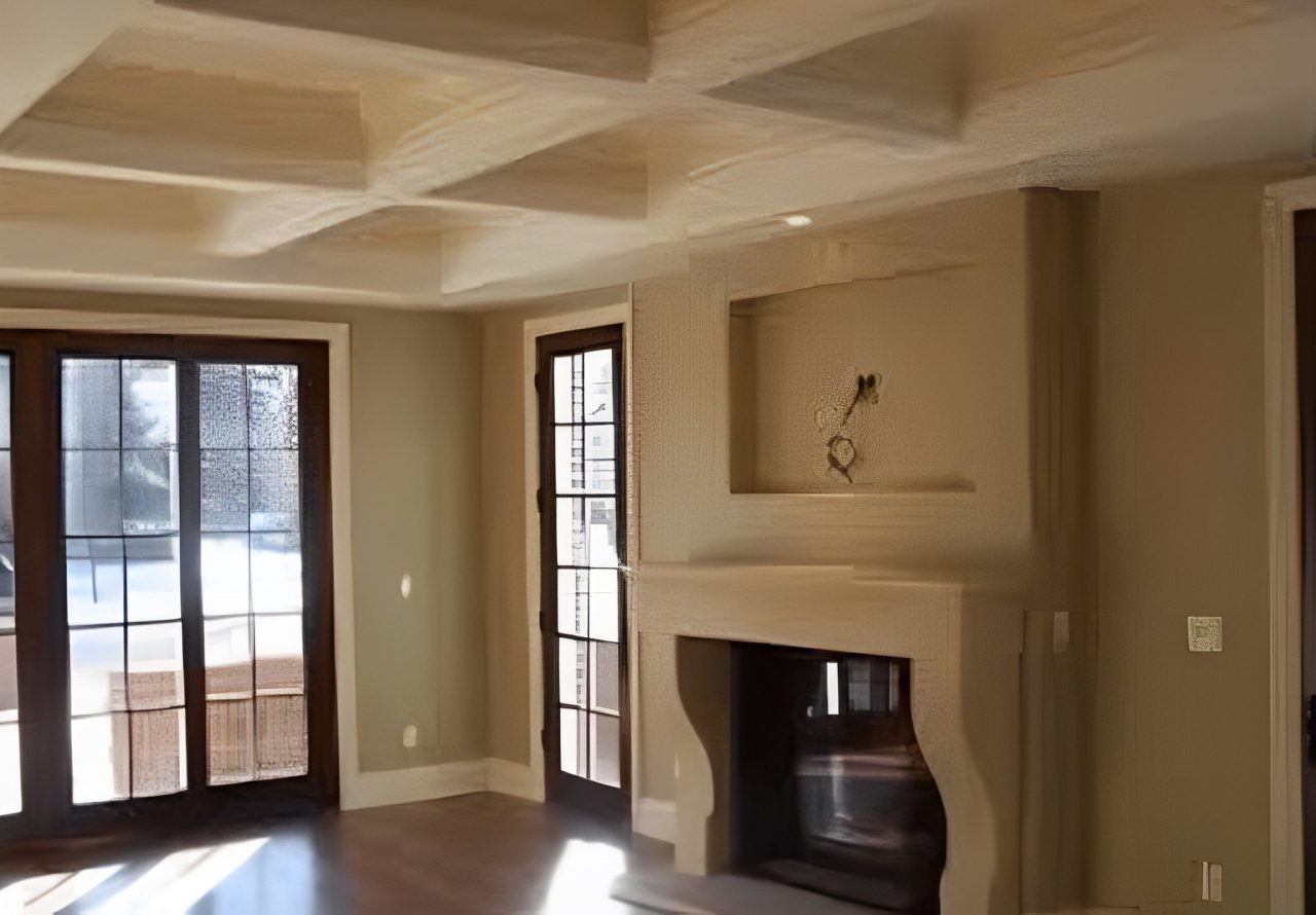 Spacious room with coffered ceiling and French doors painted in a warm neutral tone.