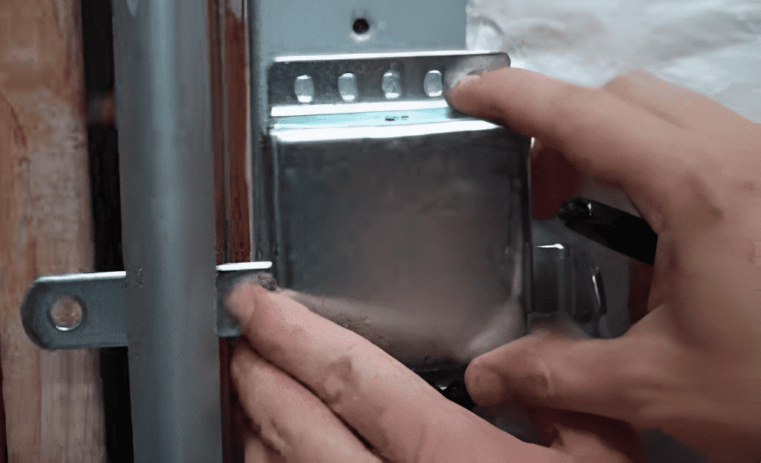 Hardware being installed on a wall-mounted track.
